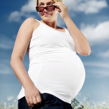 Babybauch im Blumenfeld