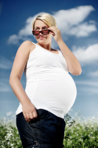 Babybauch im Blumenfeld